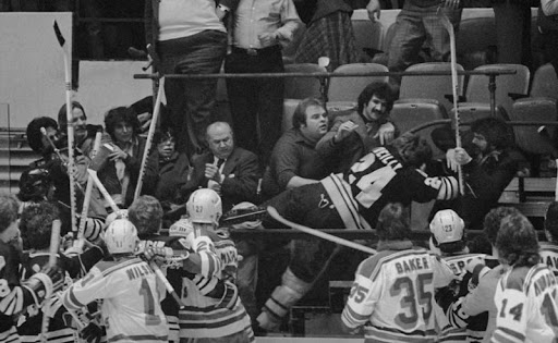 Terry O'Reilly of the Boston Bruins is helped over to the penalty