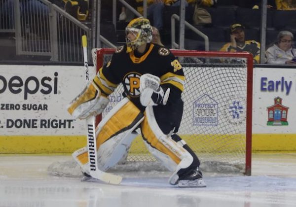 Boston Bruins goaltender Kyle Keyser is reflected by the glass